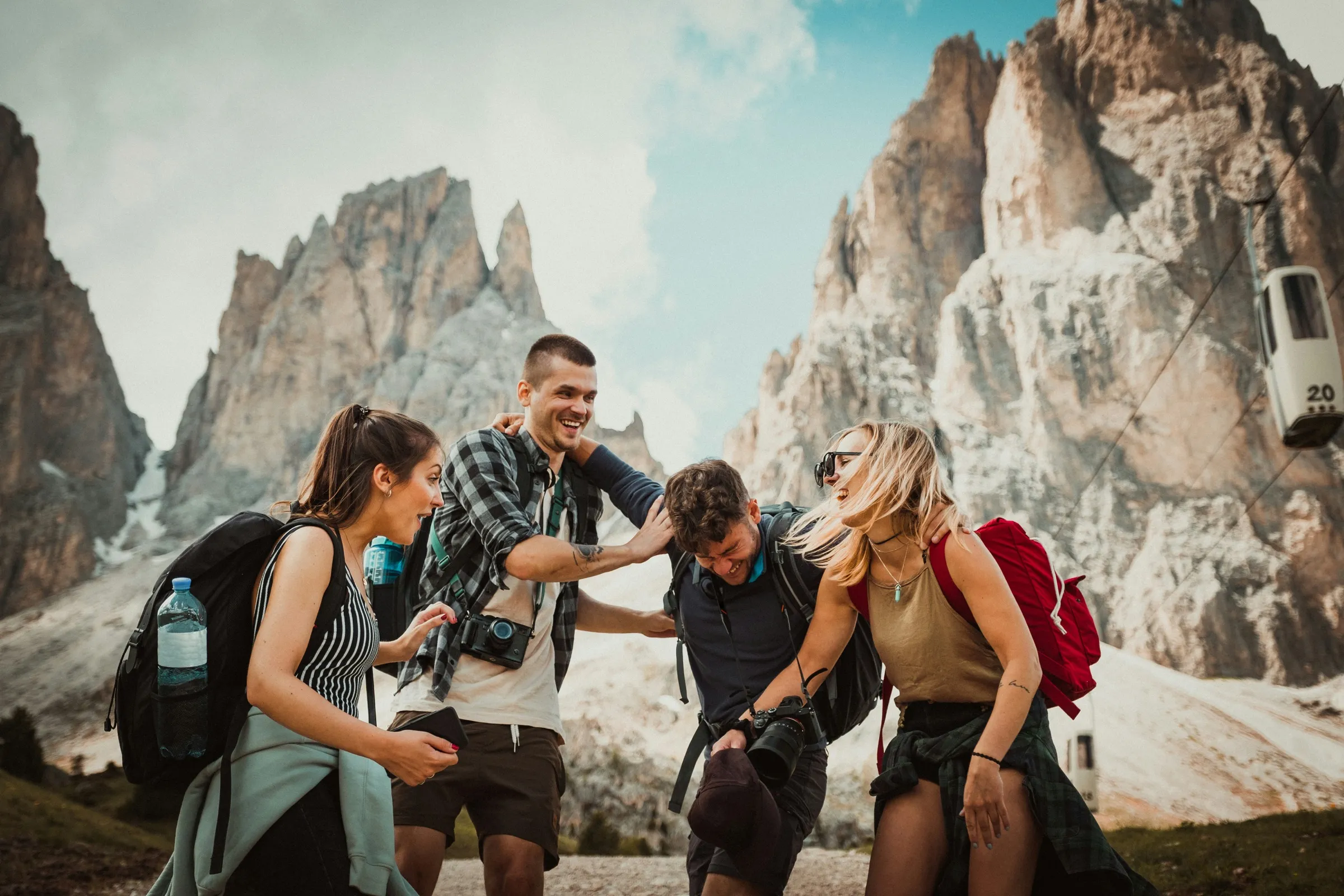 A group of hikers laughing together on a mountain trail